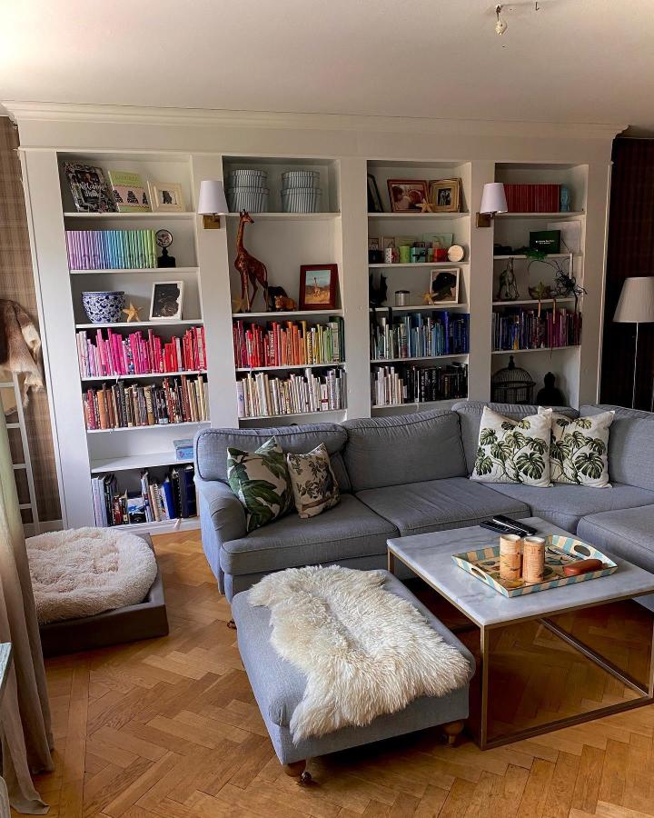White Ikea Billy bookcase with color-coordinated books and natural decor by @pernillalundkvist creating cozy compact living room style.