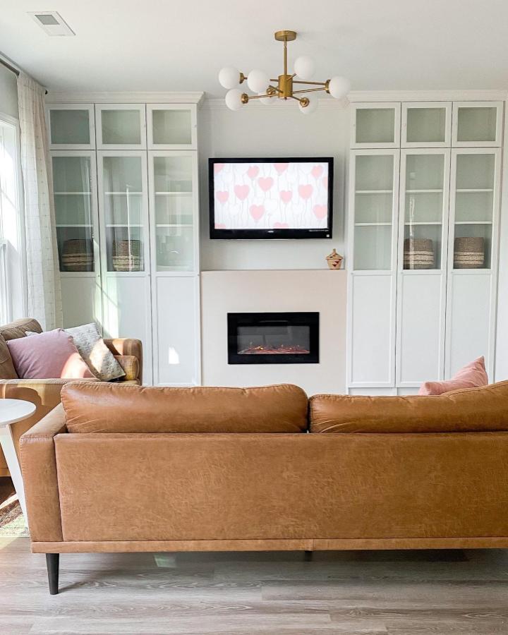 White Billy bookcases with Oxberg glass doors in a cozy living room by @farrarhome. Stylish storage for small spaces.