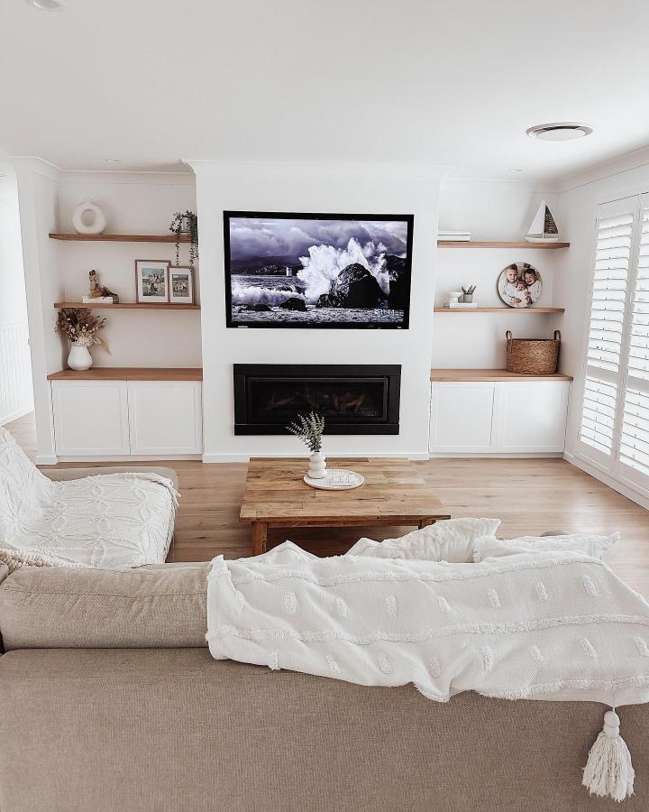 Beige Ikea Besta storage with oak shelves in living room from @the.bateman.reno showing ikea small living room hacks with clean, warm design.