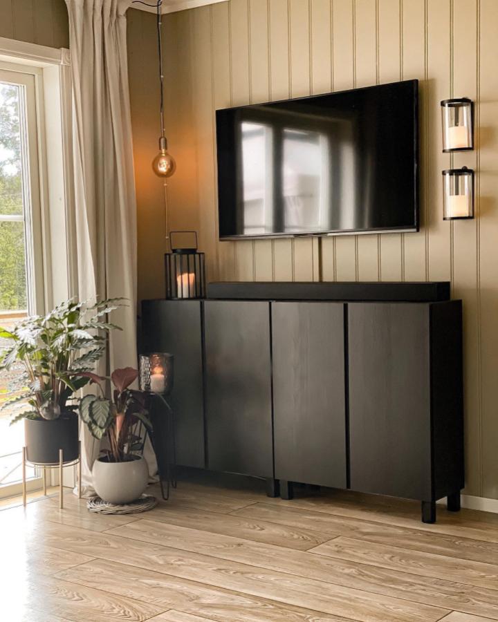 Black painted IKEA Ivar cabinet with modern legs in a cozy living room from @kines_interiorglimt Minimalist design with warm lighting and plants.