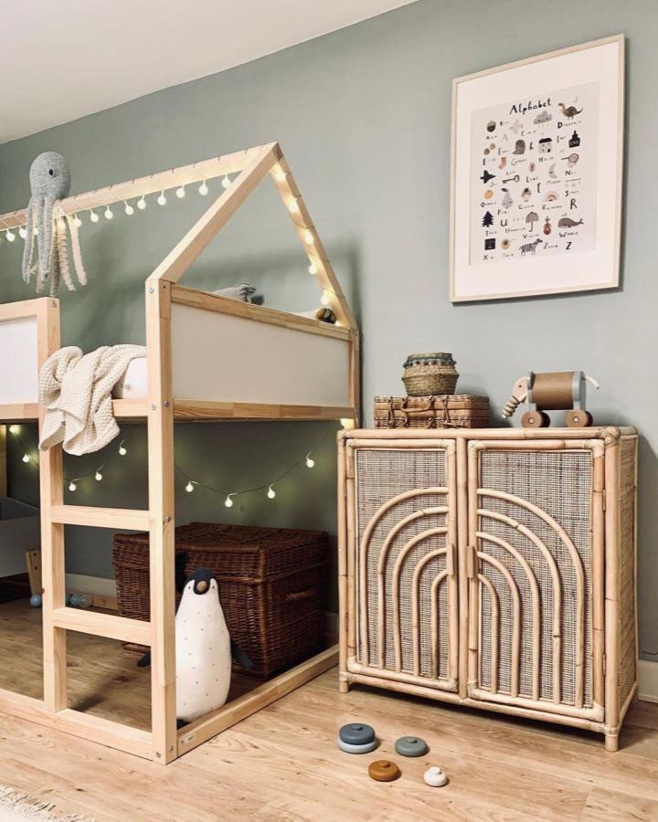 Natural wood house-frame kids’ room from @newswedishdesign. Best accessories for ikea kura beds with cream panels and white string lights
