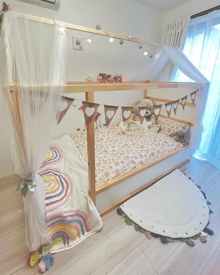 White sheer canopy KURA bed from @annabellaandemma. Fairy lights, floral bedding, and heart bunting create a cozy sleep nook.