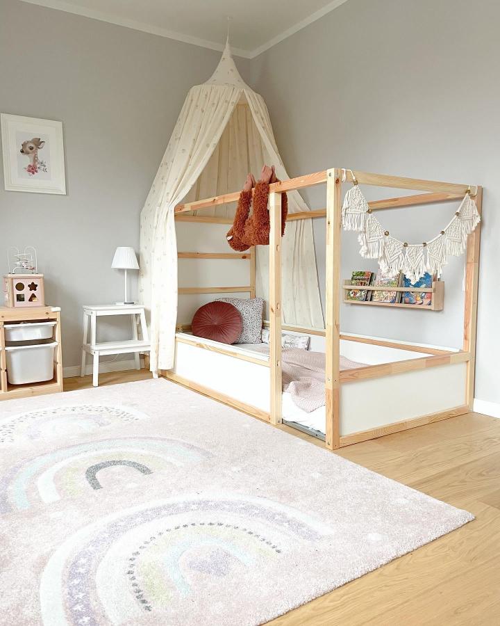 Cream canopy KURA bed from @casafuchs. Wall book sling, bunting, and cozy accessories create a storybook nook.