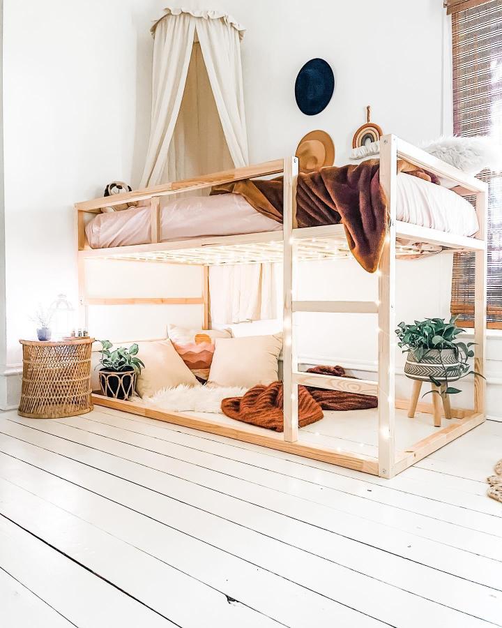Natural wood and cream KURA bedroom from @bohoburgh_bnb. Features best accessories for ikea kura beds, canopy, and reading nook.