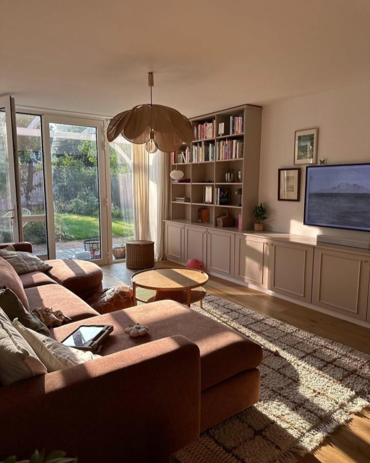 Taupe paneled living room media wall from @joandiloes. Besta cabinets frame books, decor, and television.