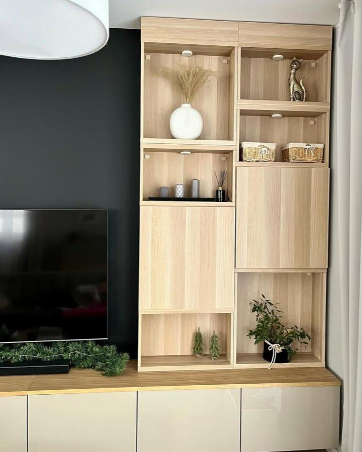 Light oak living room wall unit from @domowe_mm. Open niches, closed storage, and white Besta cabinets