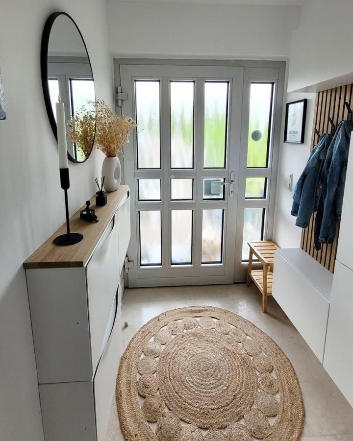 White oak-effect entryway cabinet from @reihenhaussanierung_90. Sleek Besta storage beside a round mirror and jute rug.