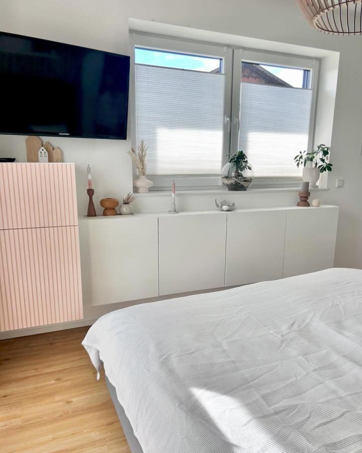 Soft pink fluted bedroom media wall from @lilas_revier. White floating cabinets create a sleek Besta arrangement.