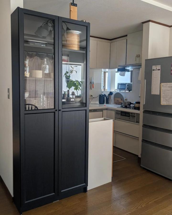 Black glass-fronted Billy bookcase room divider from @uka.home30. Oxberg doors separate the kitchen and living room.