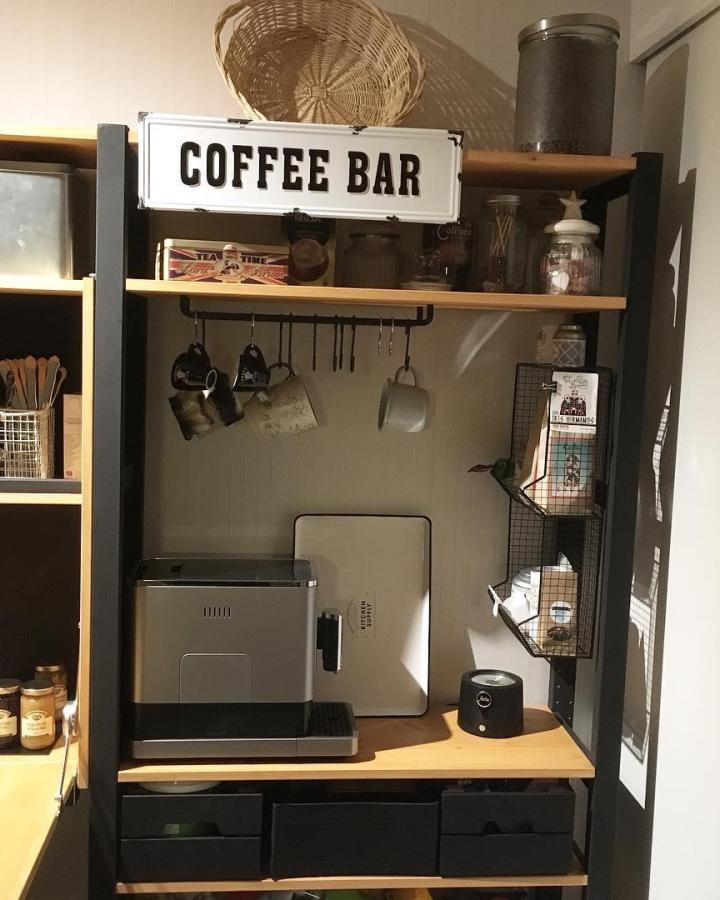 Black framed IKEA IVAR coffee station from @estrellaskulls. Natural wood shelves, hanging mugs, baskets, and espresso machine.