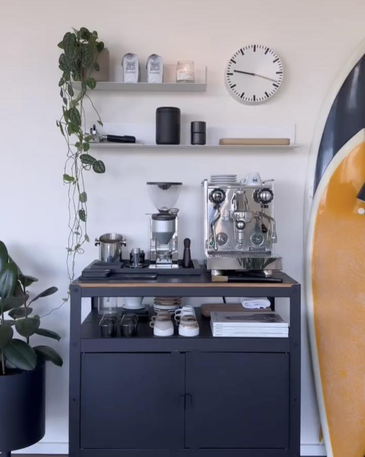 Black IKEA BROR coffee bar from @amyatiaa. Wood top, espresso machine, open shelves, and trailing plant create polished station.