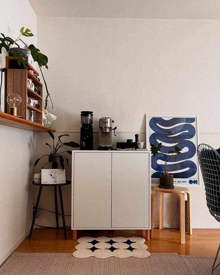 White IKEA EKET coffee bar from @___myumyu___. Wood shelves, espresso machines, plants, and blue wall art create cozy nook.