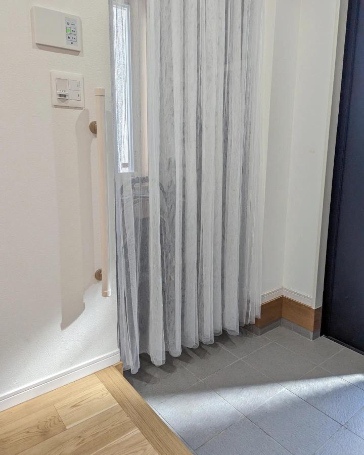 White sheer entryway curtain divider from @y.m_nizihouse21. Soft folds separate the doorway.