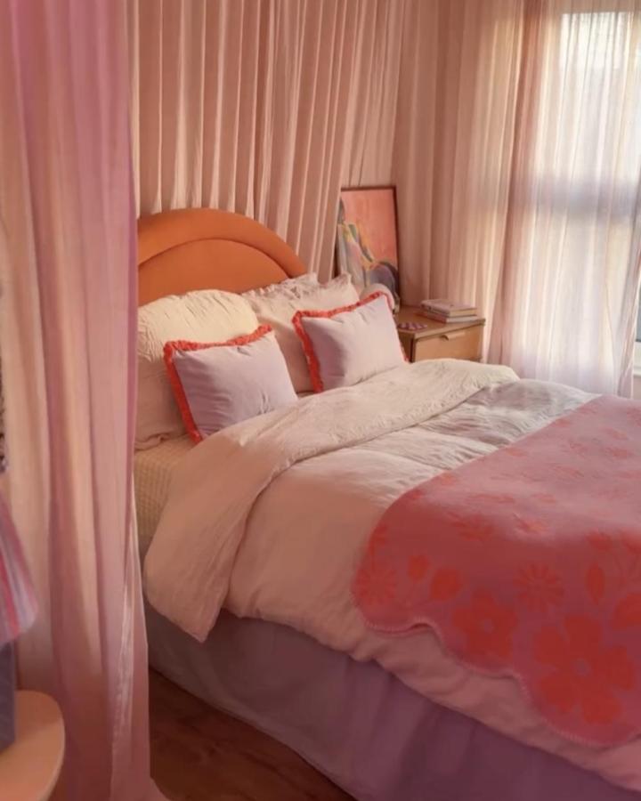 Blush pink bedroom curtain divider from @thepidgynest. SILVERLรNN sheers surround a cozy bed.