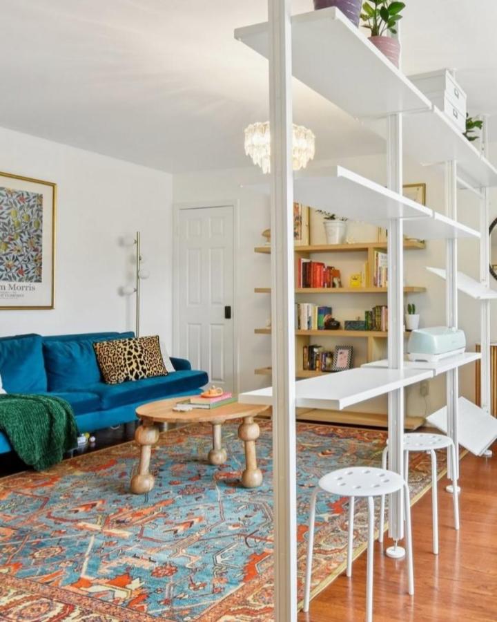 White open shelving living room from @tidylosophy. Airy ELVARLI divider with plants, books, and stools.