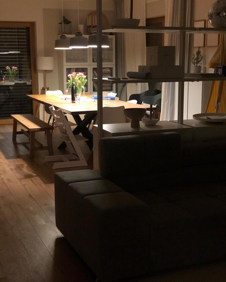 Charcoal open shelving room divider from @klein.sarah.klein. Warm dining area stays connected to the living room.
