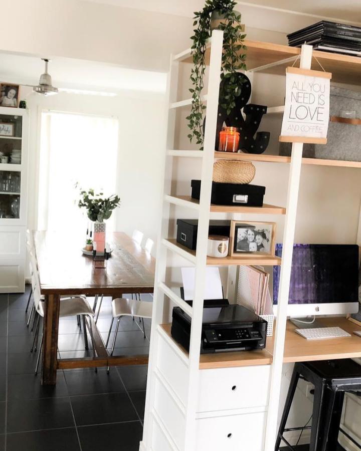 White and natural wood Elvarli room divider from @fourlittleducksbydesign. Open shelves separate the dining area from a home office.
