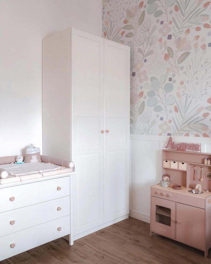 White Paneled PAX Wardrobe From @caterinaschiazza. Floral wallpaper and blush nursery accents.