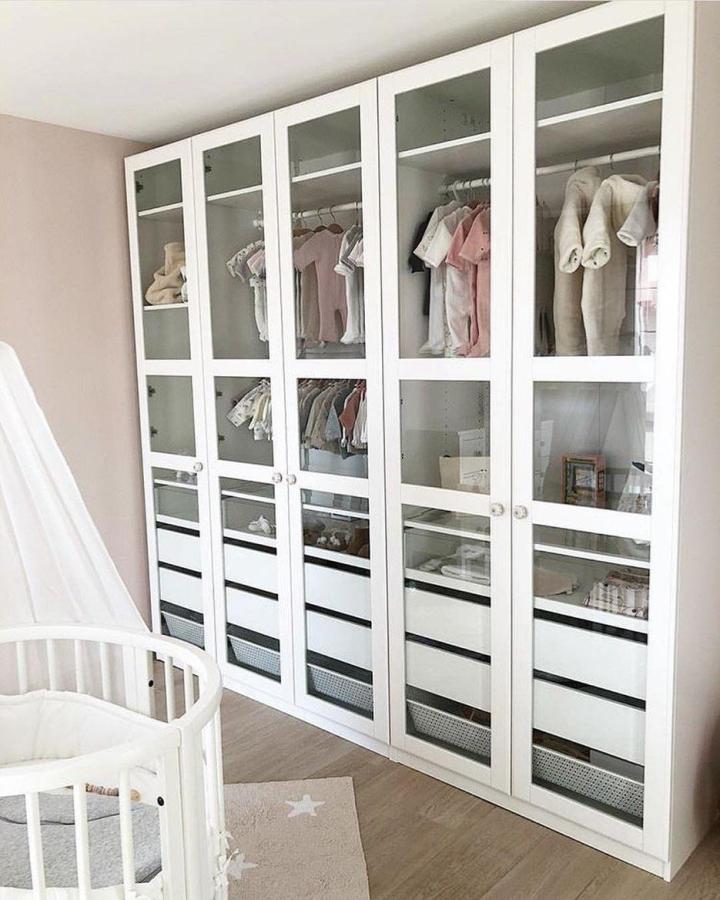 White glass-front PAX nursery wardrobe from @baby_mom_angebote. Organized baby clothes, drawers, and baskets.