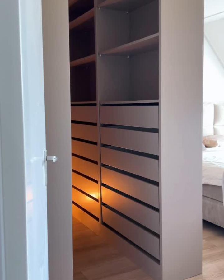 Taupe PAX wardrobe room divider from @casarebel. ikea pax room divider ideas with warm under-shelf lighting.