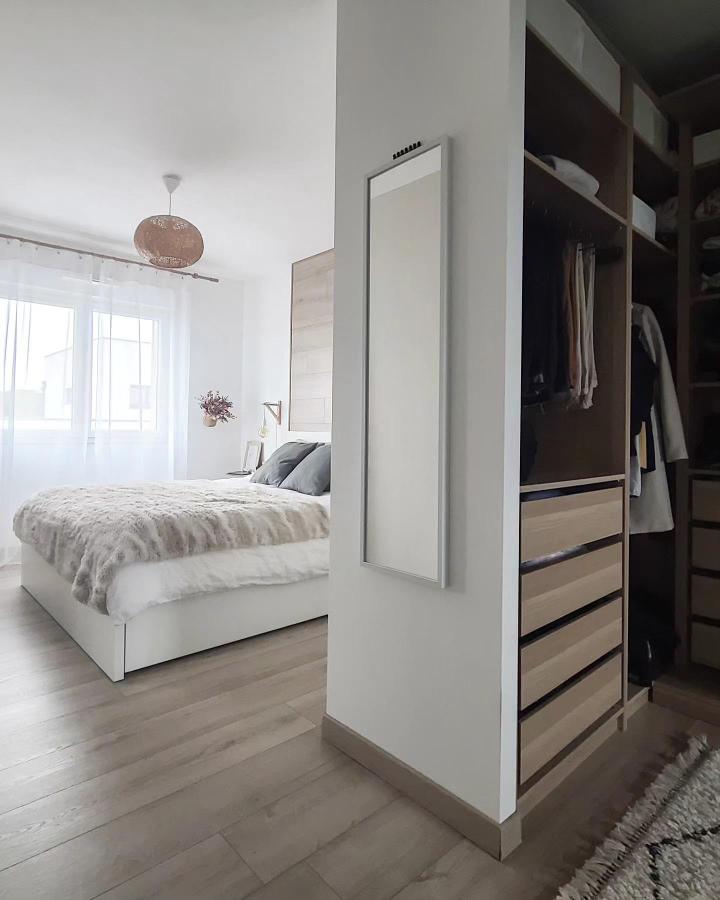 White And Wood Bedroom Divider from @les_voyageurs_font_leur_nid. Open wardrobe separates sleeping space from clothing storage.