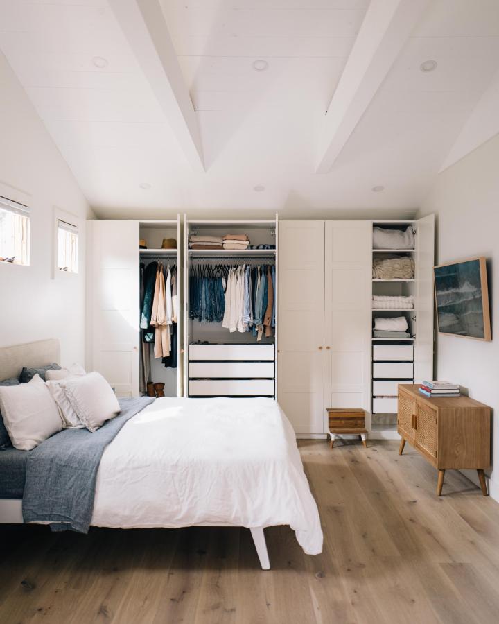 White built-in wardrobe from the new england guide. Compact bedroom storage with open shelving and hanging rails.