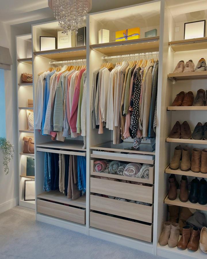 Warm neutral walk-in closet from @inside_our_nightingale_home. These ikea pax walk in closet ideas feature lit rails and shoe shelves.