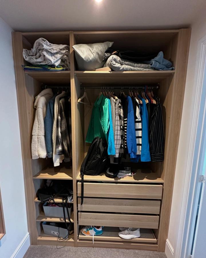 Warm wood-effect ikea pax walk in closet ideas from @leamington_lifestyle_plot124. Open rails, drawers, shelves, and shoes.