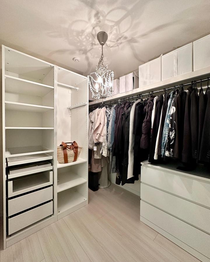 White modular walk-in closet from @a.myhome66. Open rails, drawers, shelves, and chandelier create an organized dressing space.
