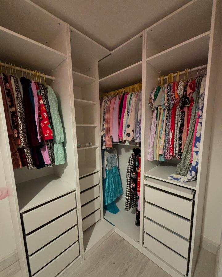 White U-shaped IKEA PAX closet from @southwest.selfbuild. Colorful clothing, drawers, shelves, and mirror suit ikea pax walk in closet ideas.