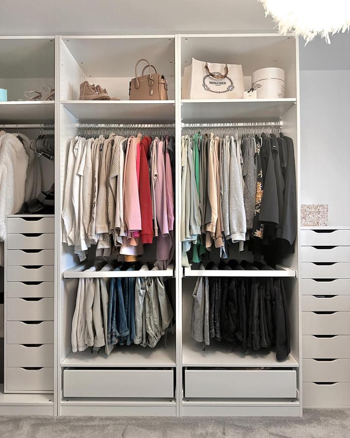 White color-coded wardrobe from @lauramaesharpehome. Open shelving, hanging rails, drawers, and folded accessories create an organized dressing room.