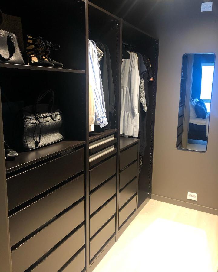 Near-black open wardrobe from @onyxen_orje. Sleek drawers, hanging clothes, handbags, mirror, and tailored storage.