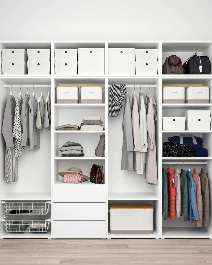 White modular wardrobe from @melinda.mea. Open cubbies, hanging rails, baskets, and colorful coats.