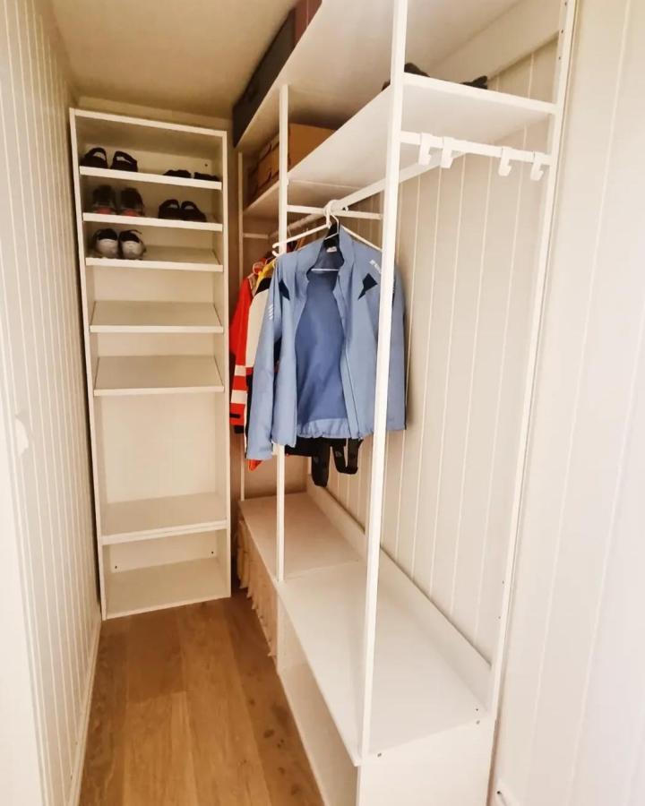 White open PLATSA wardrobe from @oyhuset. Rails, shelves, shoes, and colorful jackets fill a narrow dressing nook.