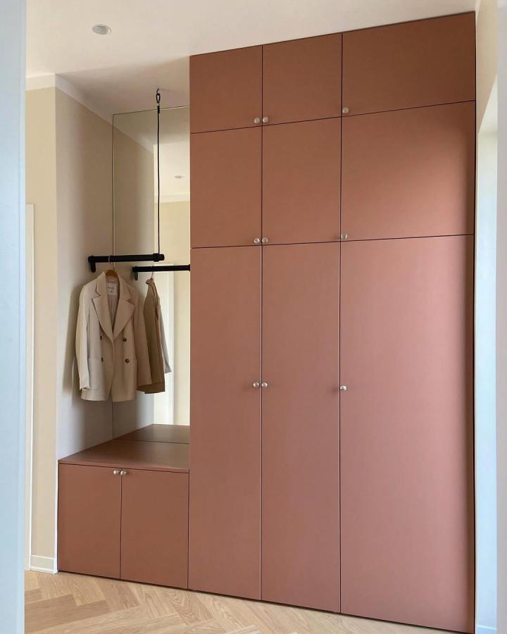 Terracotta built-in wardrobe from @hanghaus15. Muted doors, black hanging rail, and bench drawers create a tailored PLATSA entryway.