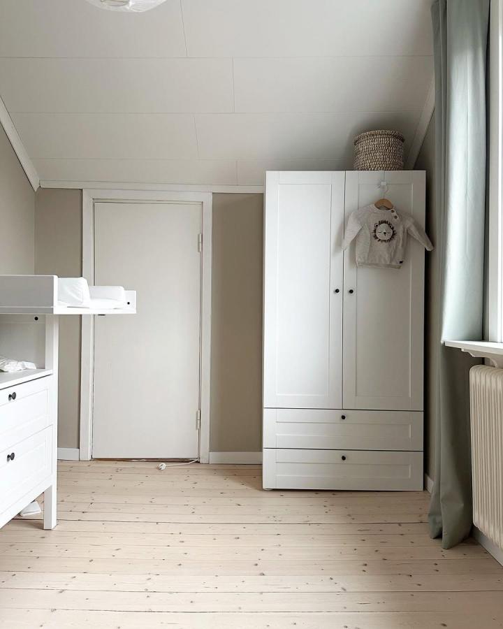 White paneled nursery wardrobe from @sarahedelius. Calm ikea platsa wardrobe ideas with drawers, hanging space, and woven basket.