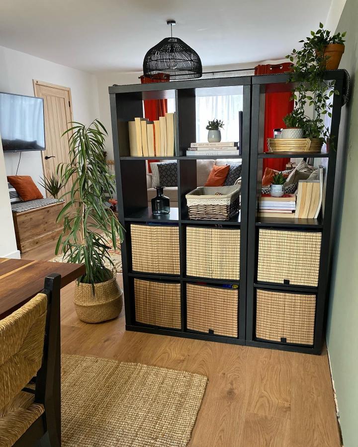 Black KALLAX room divider from @the_kenno_renovations. Woven baskets separate dining and living areas.