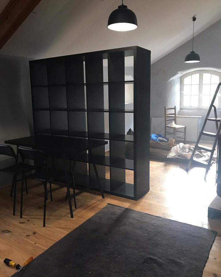 Black KALLAX shelving divider from @oursecondhand_home. Open cubes separate a studio dining nook from the living area.