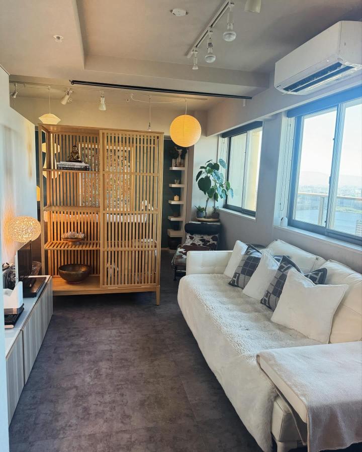 Warm wood slatted living room divider from @love.neko.love0925. ikea room divider ideas for small spaces separate sofa and display shelving.