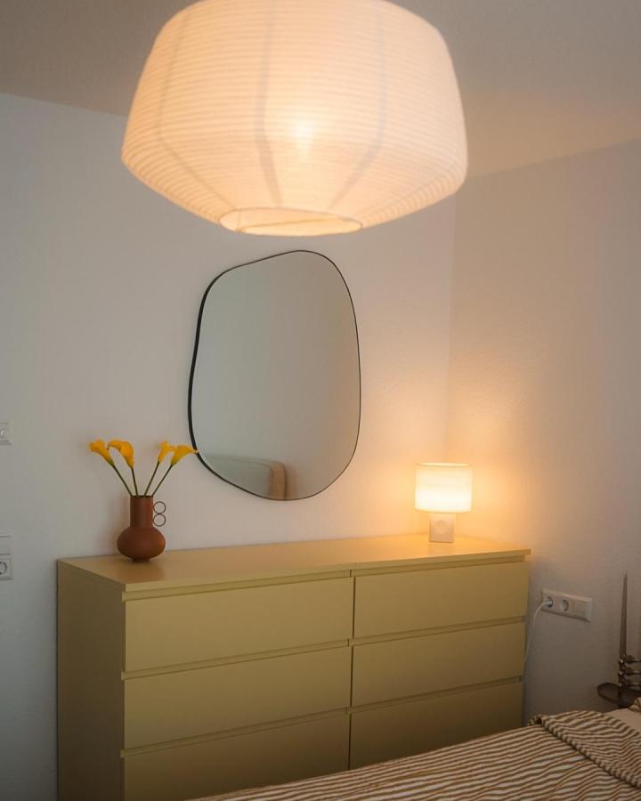 Muted olive IKEA MALM dresser from @lina_liebts. Warm lighting and mirror suit compact bedroom storage.
