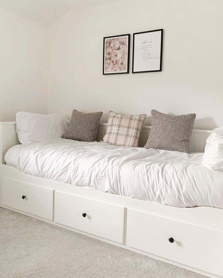 White IKEA HEMNES daybed from @homewiththewilliams. Built-in drawers, layered pillows, and framed art maximize a compact bedroom.