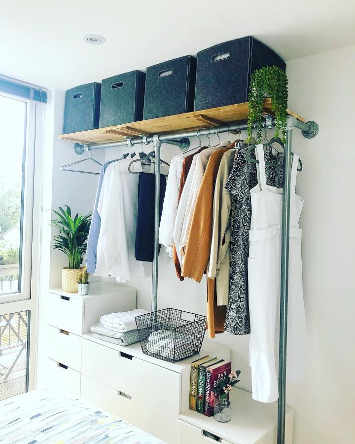White IKEA NORDLI dresser from @renoliving_devon. Stylish ikea small bedroom hacks with pipe rails and wood shelf.