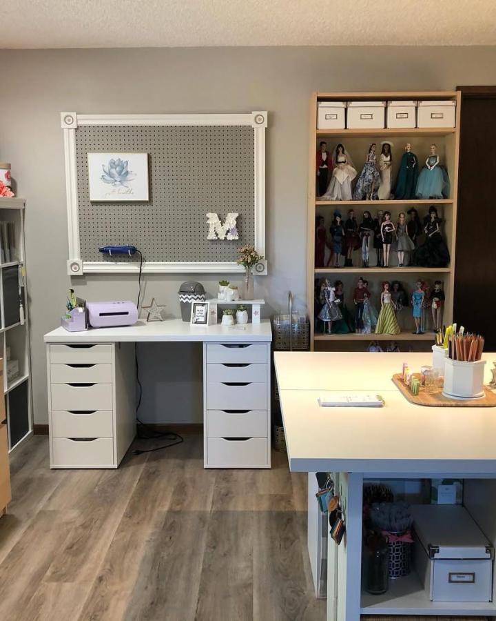White and gray craft room from @mwoerner. Framed pegboard, drawer storage, doll cabinet, and spacious worktable.