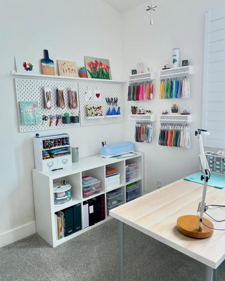 White pegboard craft room from @miss_paper_craft. Colorful threads and cube storage organize a compact creative workspace.