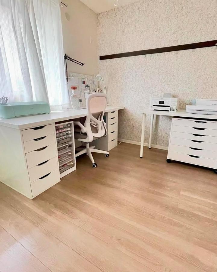 White IKEA craft room from @yuka_0bl3. Mint cutting machine, drawer storage, and pale wood flooring create an airy workspace.