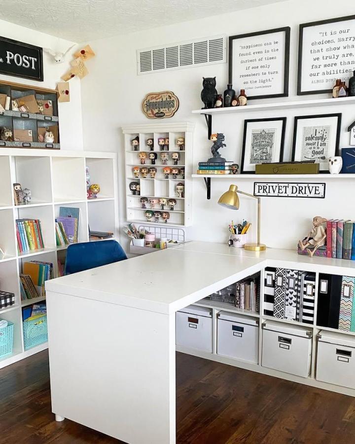 White IKEA cube-shelf craft room from @bookgirlcreations. ikea small craft room ideas with central desk and labeled storage.