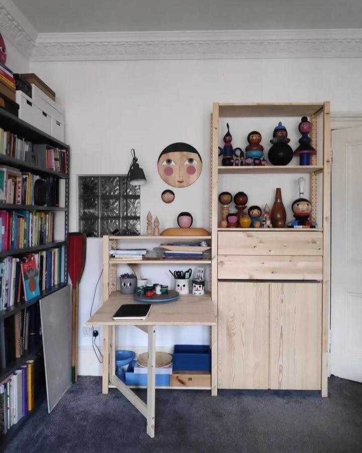 Pale pine craft room from @agata_pietrusz. Fold-down desk, open shelves, colorful dolls, and organized supplies.