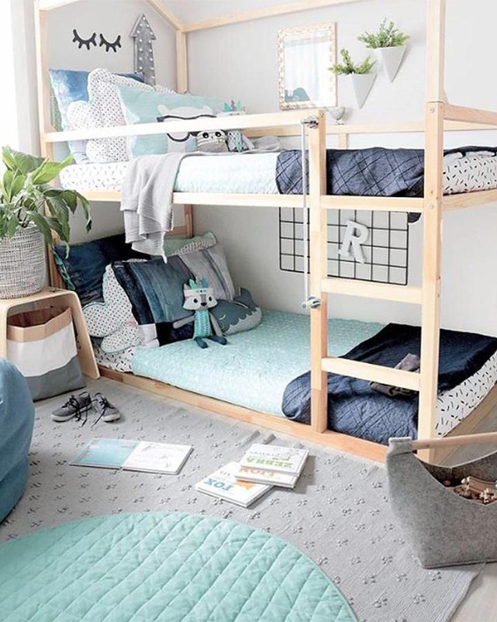 Natural wood IKEA KURA bed from @kate.fisher.art. ikea kura bed ideas for boys feature aqua bedding and a playhouse frame.