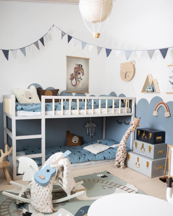 Blue-and-white bunk bed from @tuoksuajatunnelmaa. Cloud wall and playful storage create a cheerful boysโ room.