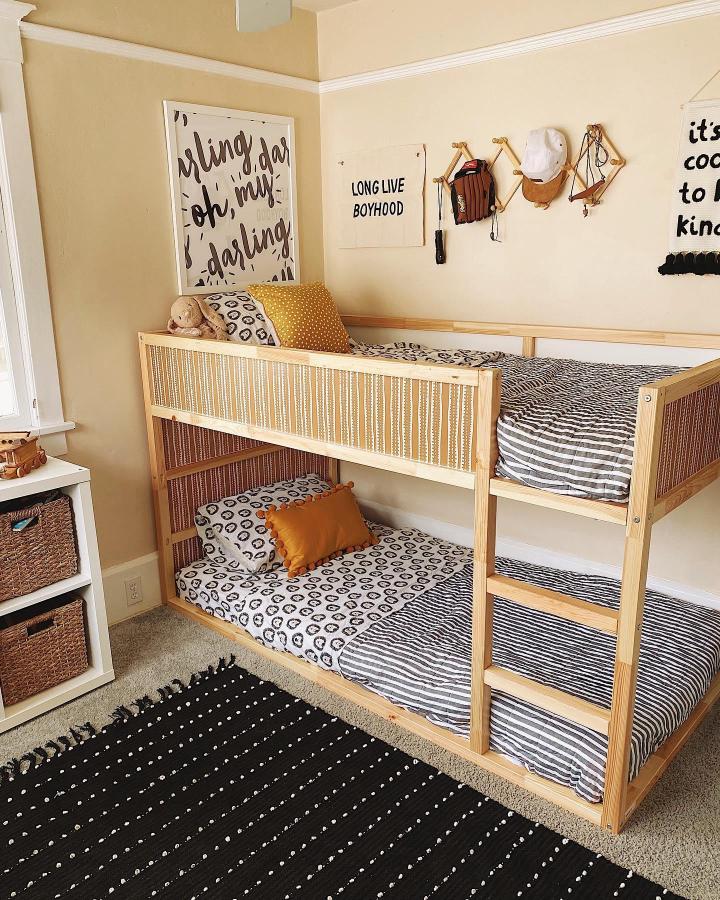 Natural wood bunk bed from @bri.dietz. Cane webbing panels, black-and-white bedding, and a cozy boysโ room.